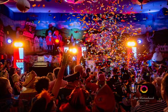 Bunte Konfetti-Explosion in festlicher Atmosphäre mit fröhlichen Feiernden.