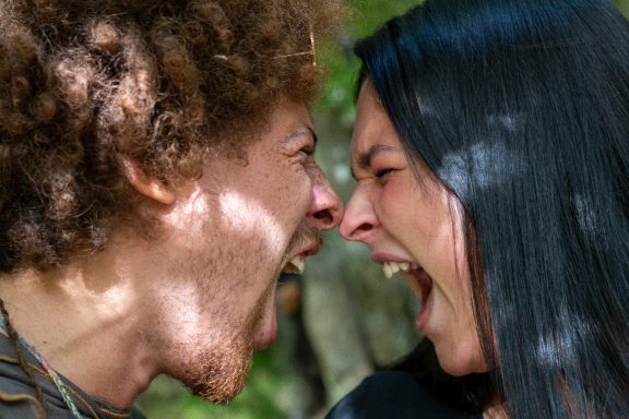 Zwei Menschen schreien einander an, mit leidenschaftlichen Gesichtsausdrücken.